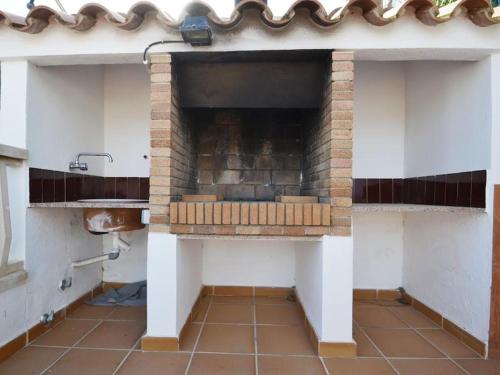 a kitchen with a brick oven with a sink at Camins 2 in Riumar