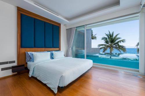 una camera con un grande letto e una grande finestra di WEG Elite Beachfront a Phuket