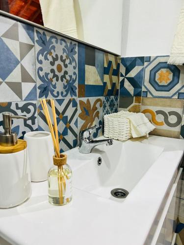 a bathroom sink with a vase and tiles on the wall at AL Chalet do Sossego in Senhora da Nazaré