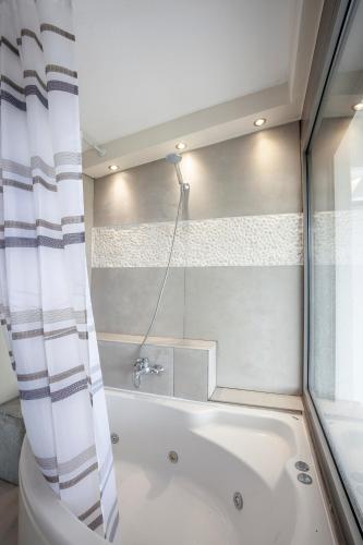 a bathroom with a bath tub and a shower at Villa Selena seafront in Hanioti