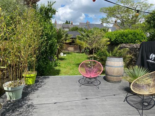 - une terrasse avec 2 chaises et un tonneau dans l'établissement Chambres d’hôtes, au Mans