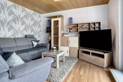 a living room with a couch and a flat screen tv at Ferienwohnung K Schröder in Sundhagen