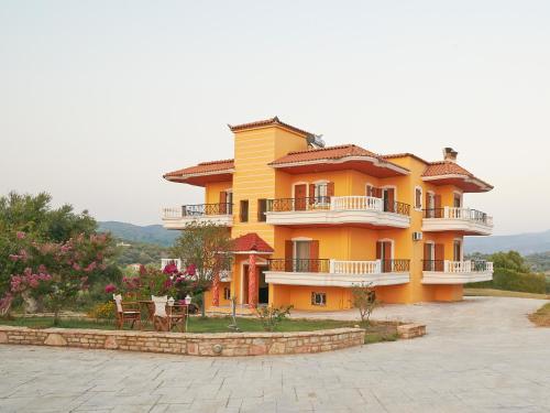 a large yellow house with a table and chairs at Foinikounta view in Finikounta