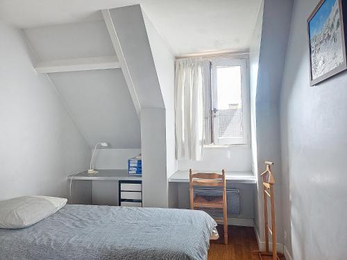 a bedroom with a bed and a desk and a window at MAISON FAMILIALE in Rueil-Malmaison