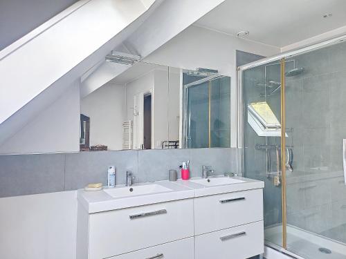 a white bathroom with a sink and a shower at MAISON FAMILIALE in Rueil-Malmaison