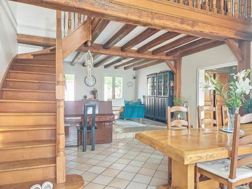 un salon avec un escalier en bois et une table dans l'établissement MAISON FAMILIALE, à Rueil-Malmaison