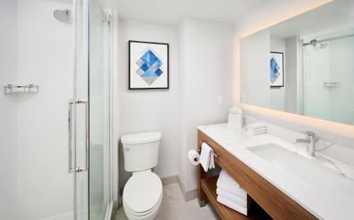 a bathroom with a toilet and a sink and a shower at Candlewood Suites Burlington Conference Centre by IHG in Burlington