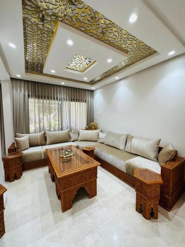 a living room with a couch and a table at Charming Villa, Breathtaking Garden View in Casablanca