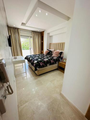 a bedroom with a bed and a table and a window at Charming Villa, Breathtaking Garden View in Casablanca