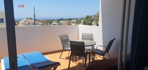 a room with a table and chairs on a balcony at Evros Peyia & Coral Bay Seaview Apartment in Peyia
