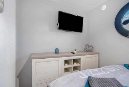 a living room with a tv on a wall at Hausboot Seeadler Stralsund in Stralsund
