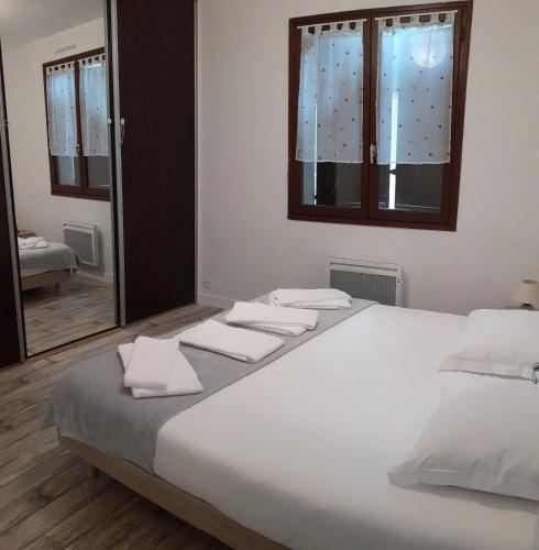 une chambre avec un grand lit blanc avec des serviettes dessus dans l'établissement Maison charmante à Seigy, vue sur jardin, accepte animaux., à Seigy