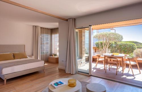 - une chambre avec un lit, une table et un balcon dans l'établissement Hameau de Piantarella, à Bonifacio