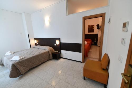a bedroom with a bed and a chair in a room at Hotel Okinawa in Rimini