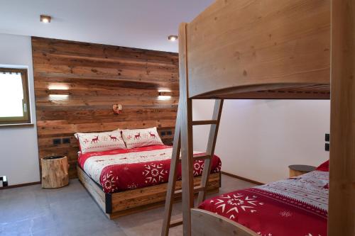 a bedroom with a bunk bed and a wooden wall at Chalet Aquila - Chalet Maso Vecchio fra le montagne del Trentino in Castello Tesino