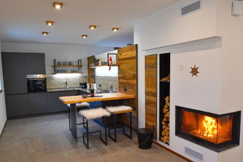 a kitchen with a table and a fireplace at Chalet Aquila - Chalet Maso Vecchio fra le montagne del Trentino in Castello Tesino