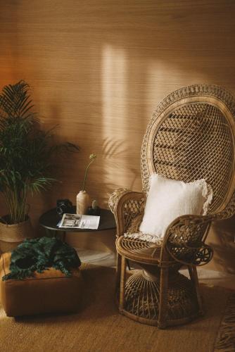 a wicker chair with a pillow and a table at 2Places Soul in Lörrach