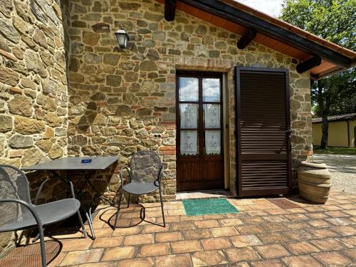 a patio with chairs and a table in front of a building at Agriturismo LeGi Toscana in Pietraviva