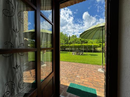 a window view of a patio with an umbrella at Agriturismo LeGi Toscana in Pietraviva