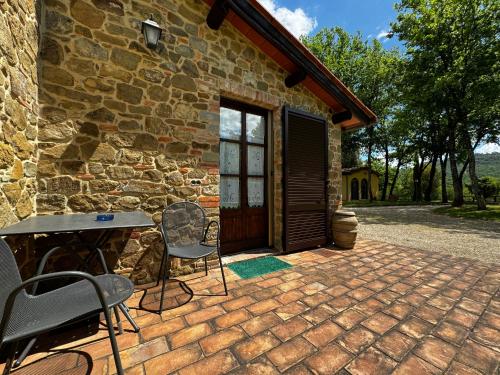 a patio with chairs and a table in front of a building at Agriturismo LeGi Toscana in Pietraviva