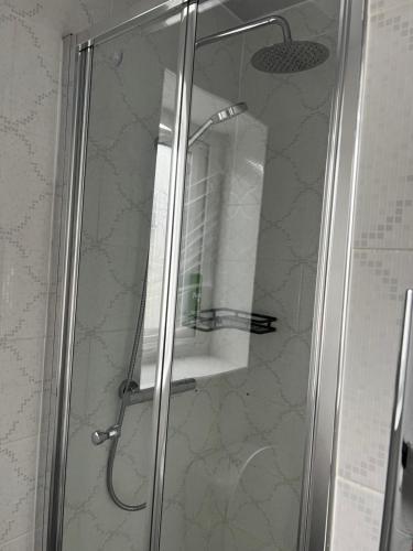 um chuveiro com uma porta de vidro com um rolo de papel higiénico em Dane Guest House Free Parking Fast WiFi Modern Living em Burnley