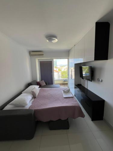 ein Schlafzimmer mit einem Bett und einem TV in der Unterkunft Bellissima by the Sea in Makarska