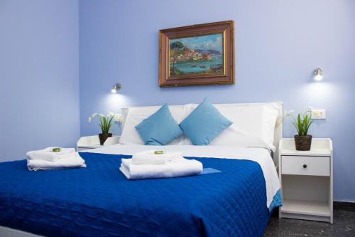 a blue bedroom with a bed with towels on it at B&B Corso Italia in Pisa