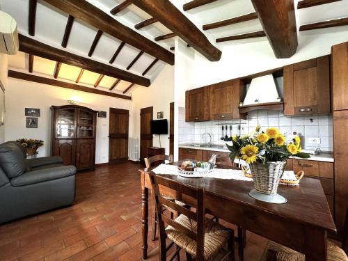 a kitchen with a table with a vase of flowers on it at Agriturismo LeGi Toscana in Pietraviva