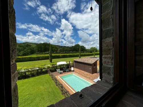 a view of a swimming pool from a window at Agriturismo LeGi Toscana in Pietraviva