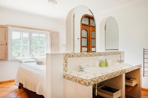 a bathroom with a sink and a bed at B&B Entrecolinas in Paderne