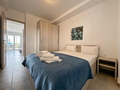 ein Schlafzimmer mit einem Bett mit Handtüchern darauf in der Unterkunft Blue Horizon 2 in Nea Kallikratia