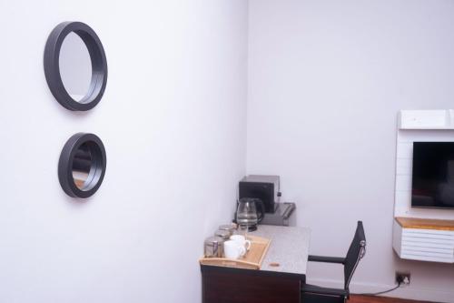 a mirror hanging on a wall next to a desk at Safi Suites and Conference Centre in Mthatha