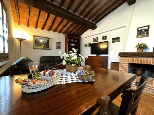 a living room with a wooden table and a fireplace at Agriturismo LeGi Toscana in Pietraviva