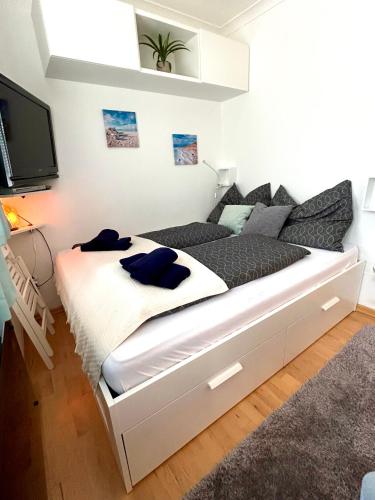 a white bed in a room with a tv at Apartment Schladming mit Sauna und Pool in Schladming