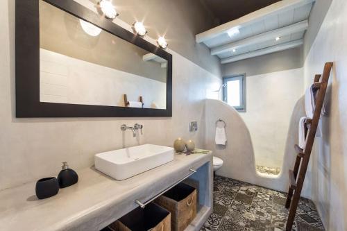 a bathroom with a sink and a mirror at SeaSalt Dream Villa,Santa Maria 5 min from Naousa in Santa Marina