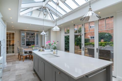 an open kitchen with a white counter top and a table at St Martin's House in Chichester