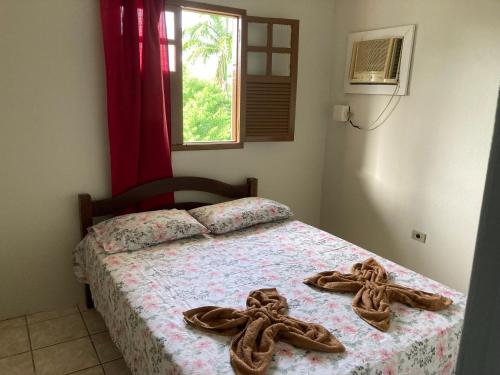 Un dormitorio con una cama con zapatos. en Apartamento Dom Ximenes, en Porto de Galinhas