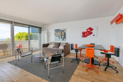 un salon avec une table et des chaises dans l'établissement Appartement face mer sur plage, à La Baule