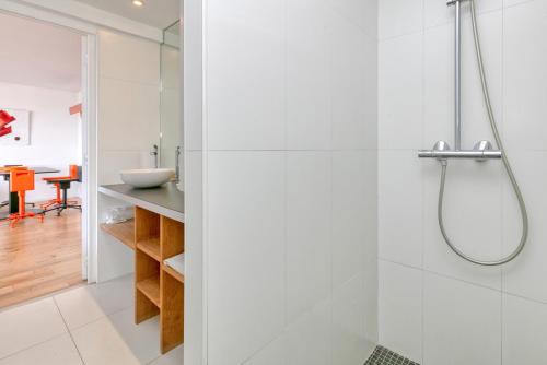 La salle de bains blanche est pourvue d'une douche et d'une table. dans l'établissement Appartement face mer sur plage, à La Baule