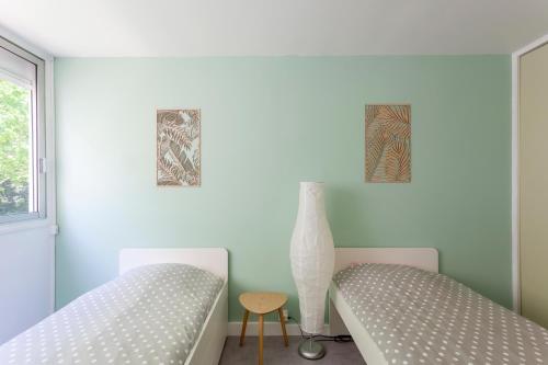 - une chambre avec deux lits et un vase dans l'établissement Chez Marylène - Spacieux appartement proche des plages & commerces, à La Grande Motte