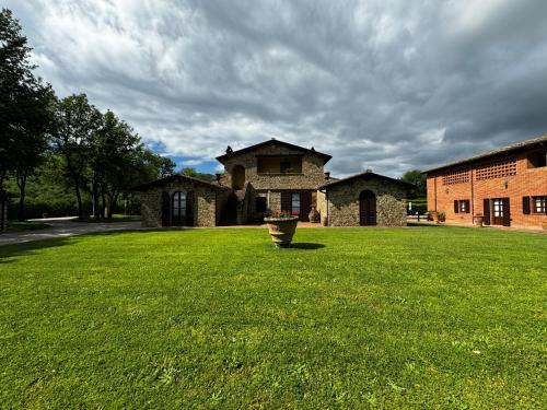 a large yard with a house and a building at Agriturismo LeGi Toscana in Pietraviva