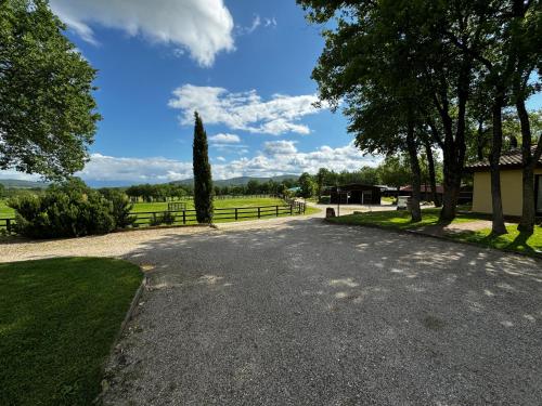 a gravel road with a tree and a fence at Agriturismo LeGi Toscana in Pietraviva