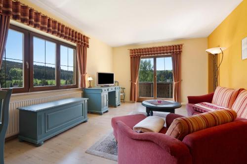 a living room with two couches and a tv at Pension Bergblick in Marienberg
