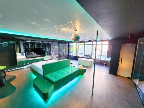 um quarto com um sofá verde e uma cama em Andar de Cima Suítes em São Paulo