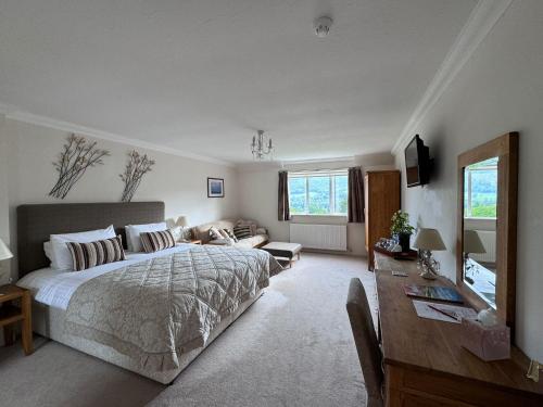 a bedroom with a bed and a desk and a couch at Beinn Bhracaigh in Pitlochry