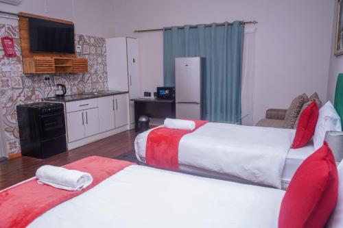 une chambre d'hôtel avec deux lits et une cuisine dans l'établissement Safi Suites and Conference Centre, à Mthatha