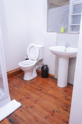 a bathroom with a toilet and a sink at Safi Suites and Conference Centre in Mthatha