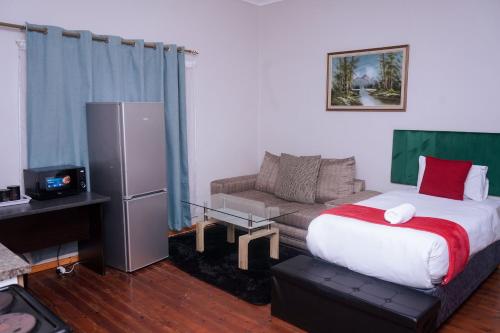 een hotelkamer met een bed en een bank bij Safi Suites and Conference Centre in Mthatha