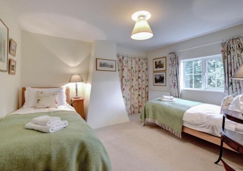 een slaapkamer met 2 bedden en een raam bij Boot Cottage in Sudbourne