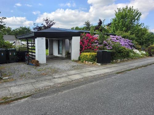 una pequeña casa con flores a un lado de la carretera en Flat, heart of Billund, 600m to Lego House, close to Legoland, Lalandia, Airport, en Billund